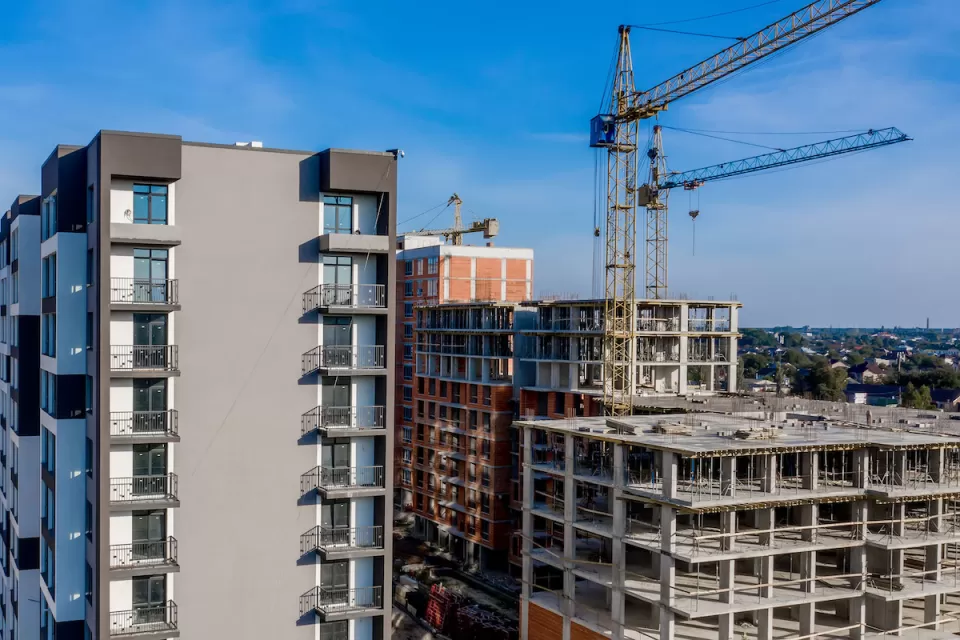 Multistory buildings under construction in a dense city with cranes.